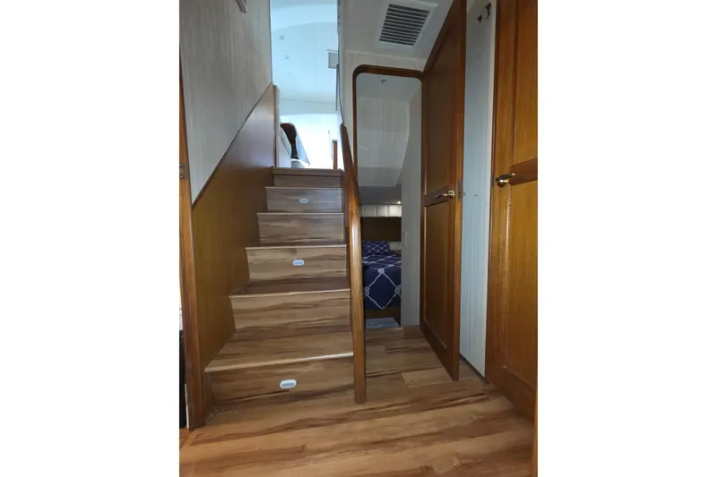 Slide: The Image of Interior view of 2002 Ocean 56 Super Sport yacht with wooden stairs and cabin access. - 11
