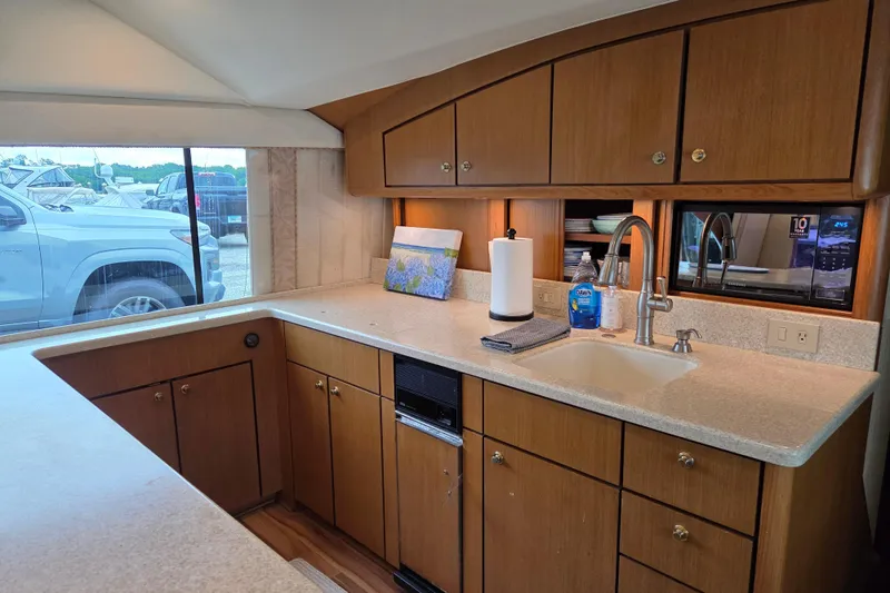 Slide: The Image of Interior of 2002 Ocean 56 Super Sport yacht kitchen with wooden cabinets and modern amenities. - 6