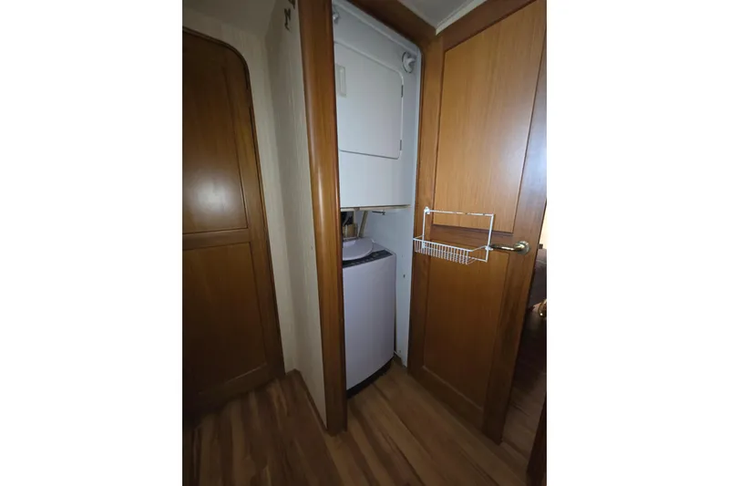 Slide: The Image of Laundry area inside 2002 Ocean 56 Super Sport yacht with wooden doors and flooring. - 25