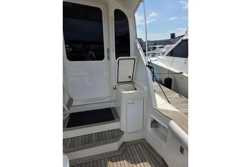 Slide: The Image of 2002 Ocean 56 Super Sport yacht deck with open hatch and dock view. - 30