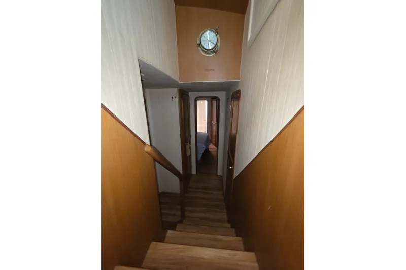 Slide: The Image of Interior staircase of 2002 Ocean 56 Super Sport yacht with wooden paneling and nautical clock. - 10