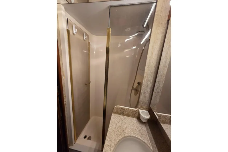 Slide: The Image of Shower area in 2002 Ocean 56 Super Sport yacht, featuring glass door and beige interior. - 16