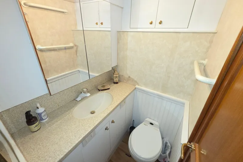 Slide: The Image of Compact bathroom in 2002 Ocean 56 Super Sport yacht with sink, mirror, and toilet. - 19