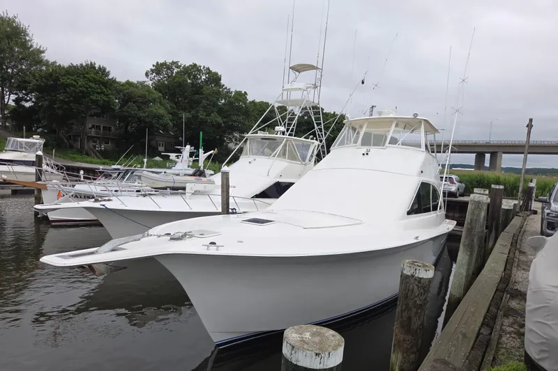 Slide: The Image of 2002 Ocean 56 Super Sport yacht docked at marina with bridge in background. - 1