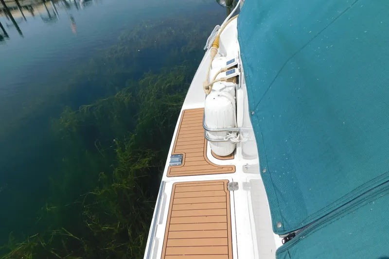 Slide: The Image of 1993 Silverton 34 Express boat deck with teal cover and clear water view. - 8