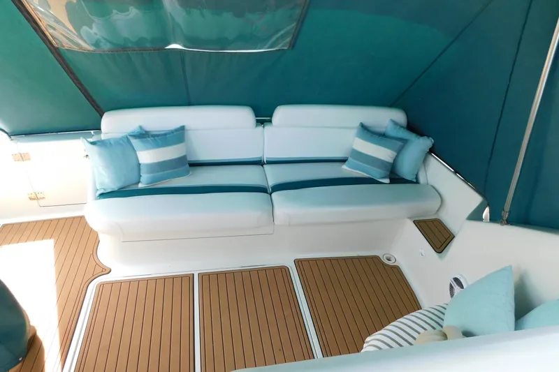 Slide: The Image of Interior of a 1993 Silverton 34 Express yacht with cushioned seating and striped pillows. - 15