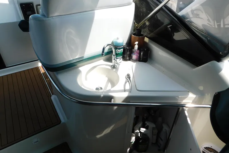 Slide: The Image of Interior of a 1993 Silverton 34 Express boat featuring a compact sink and storage area. - 23