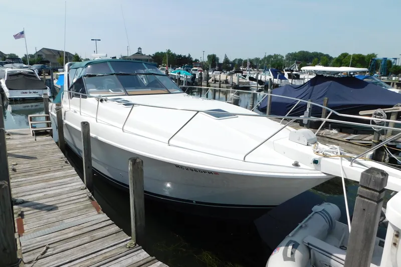 Slide: The Image of 1993 Silverton 34 Express yacht docked at marina, showcasing sleek design and spacious deck. - 5