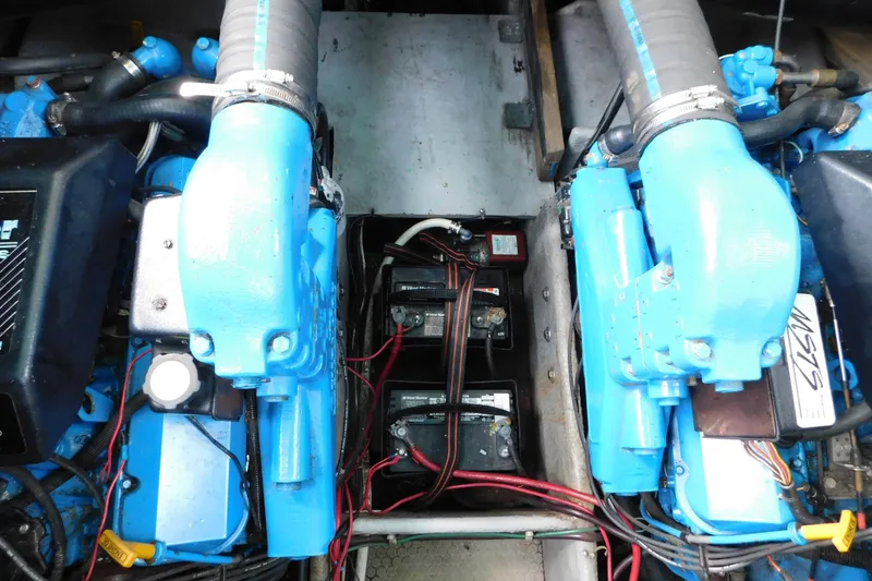 Slide: The Image of Engine compartment of a 1993 Silverton 34 Express boat with visible blue engines and wiring. - 77