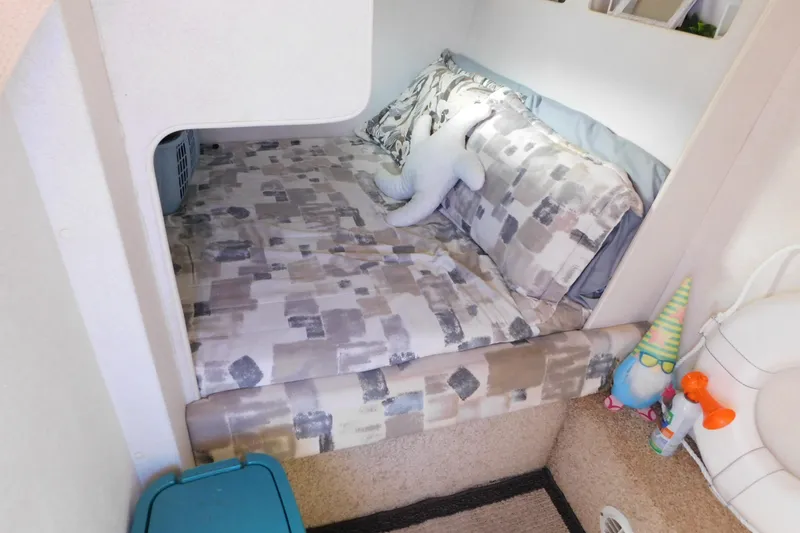 Slide: The Image of Cozy cabin bed in 1993 Silverton 34 Express boat with patterned bedding and plush toy. - 62