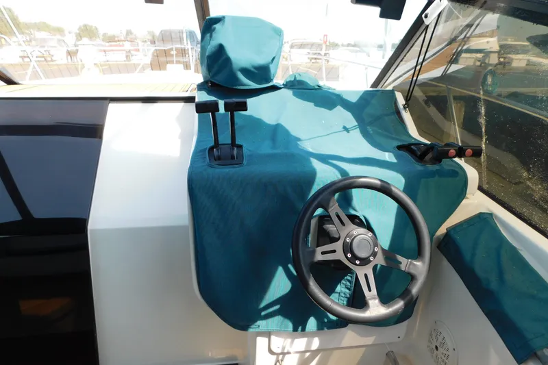 Slide: The Image of 1993 Silverton 34 Express boat helm with teal cover and steering wheel. - 18