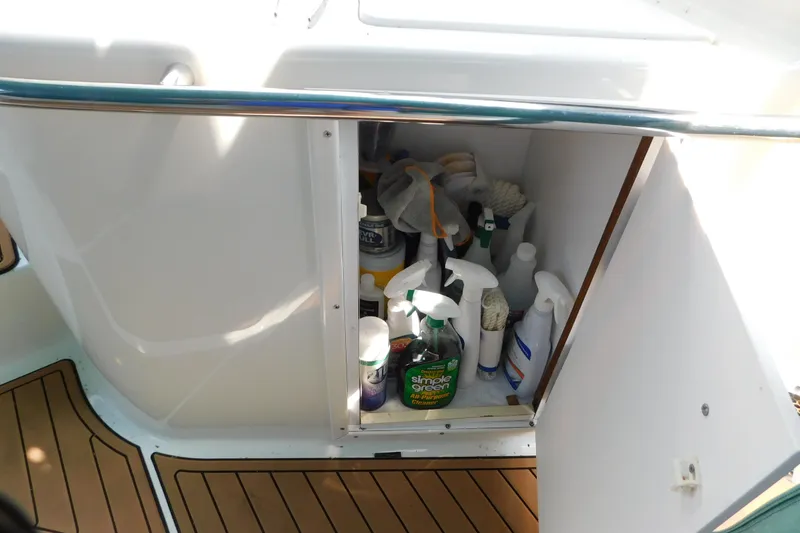 Slide: The Image of Open storage cabinet on 1993 Silverton 34 Express boat, containing various cleaning supplies. - 24
