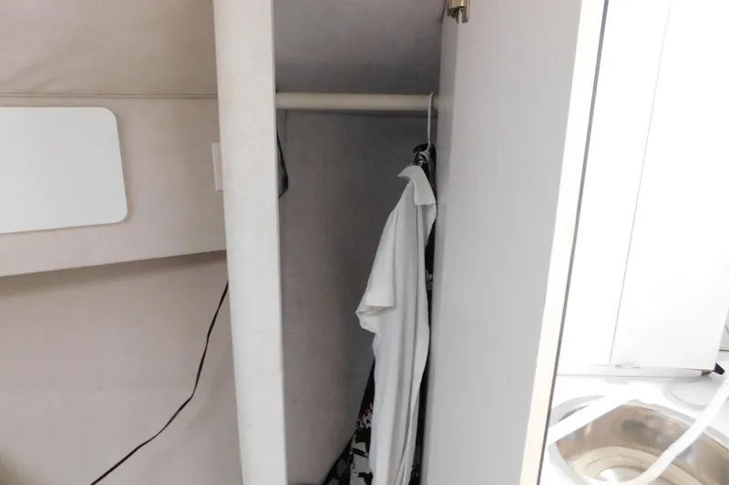 Slide: The Image of Interior closet of 1993 Silverton 34 Express boat with hanging clothes. - 45