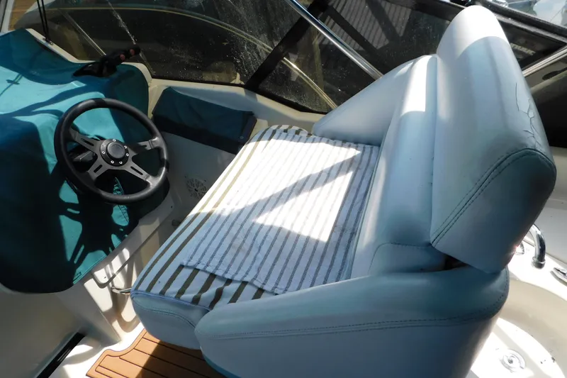 Slide: The Image of 1993 Silverton 34 Express boat cockpit with steering wheel and cushioned seating. - 17