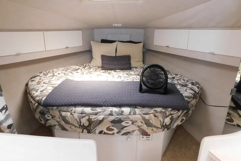 Slide: The Image of Cozy cabin interior of 1993 Silverton 34 Express with floral bedding and compact fan. - 50