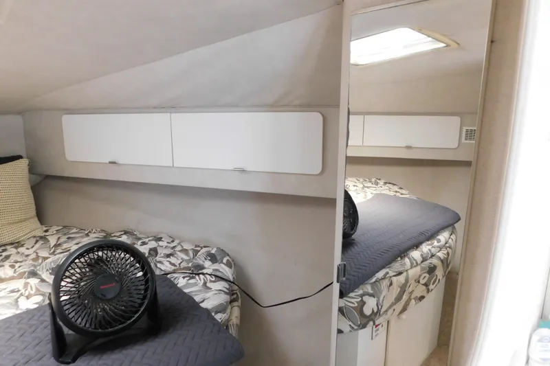 Slide: The Image of Cozy cabin interior of 1993 Silverton 34 Express with floral bedding and compact fan. - 51