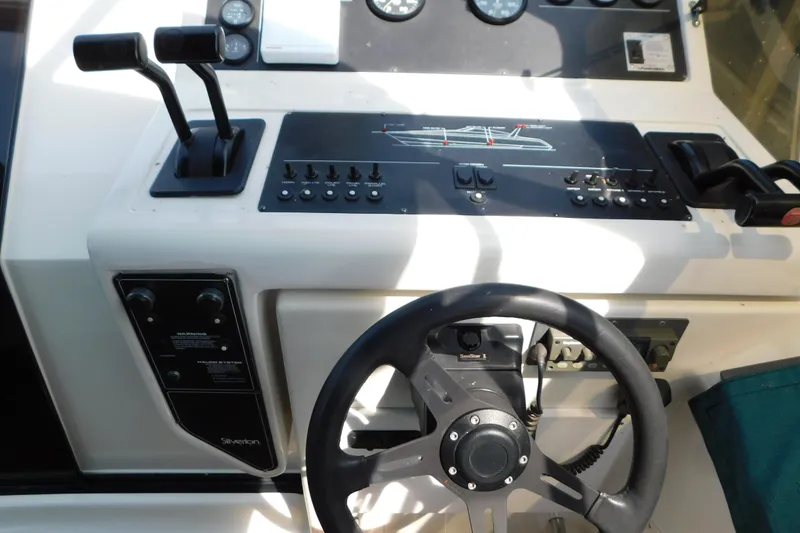 Slide: The Image of Control panel of a 1993 Silverton 34 Express boat with steering wheel and throttle levers. - 20