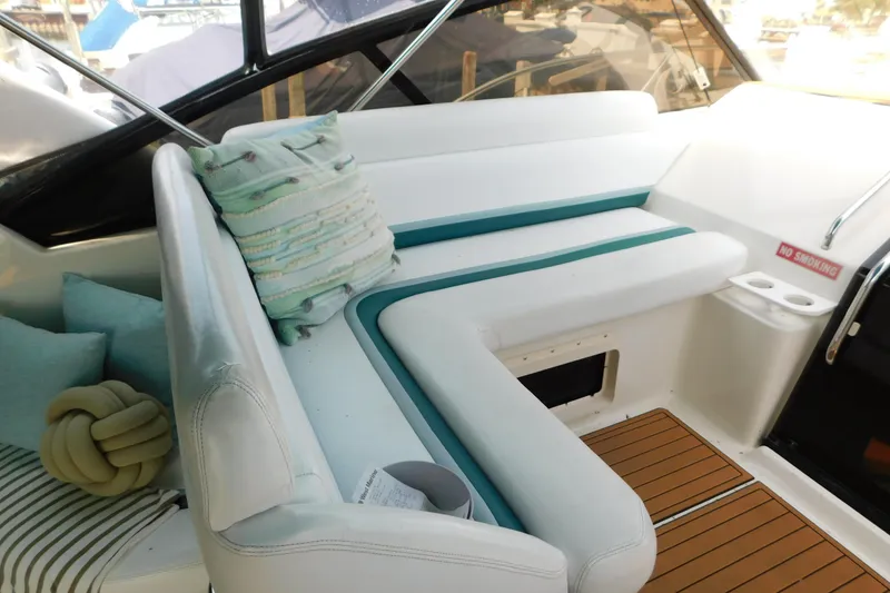 Slide: The Image of Interior of 1993 Silverton 34 Express boat with white seating and teal accents. - 26