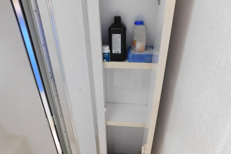 Slide: The Image of Storage cabinet inside 1993 Silverton 34 Express boat, containing bottles and containers. - 73