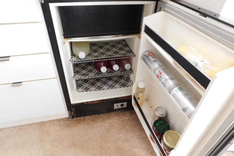 Slide: The Image of 1993 Silverton 34 Express boat refrigerator with drinks and food items inside. - 44