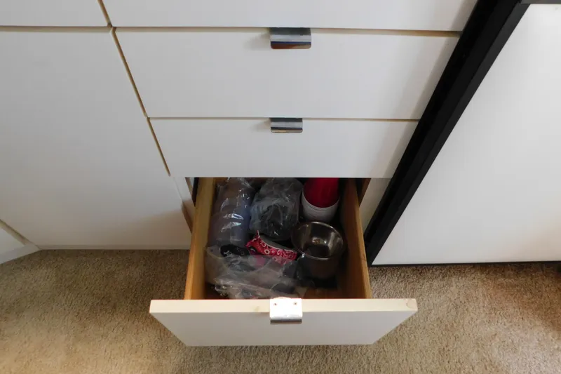 Slide: The Image of Open drawer with assorted items in a 1993 Silverton 34 Express boat interior. - 49