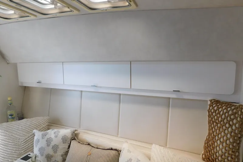 Slide: The Image of Interior of 1993 Silverton 34 Express yacht with cozy cushions and overhead storage. - 59