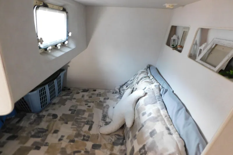 Slide: The Image of Cozy cabin interior of 1993 Silverton 34 Express boat with patterned bedding and porthole window. - 64