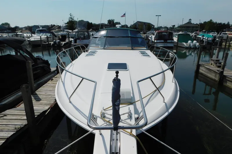 Slide: The Image of 1993 Silverton 34 Express yacht docked at marina, showcasing sleek design and spacious deck. - 4