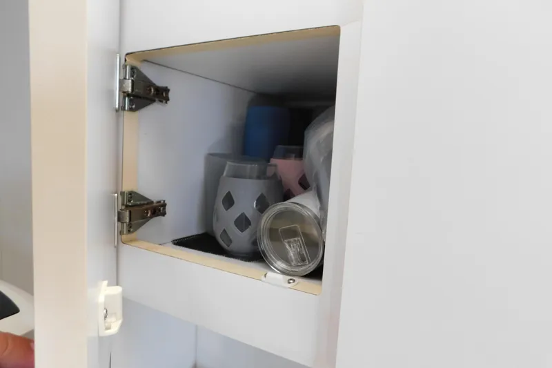 Slide: The Image of Open cabinet with assorted items inside, including a gray container and a metal can. - 39