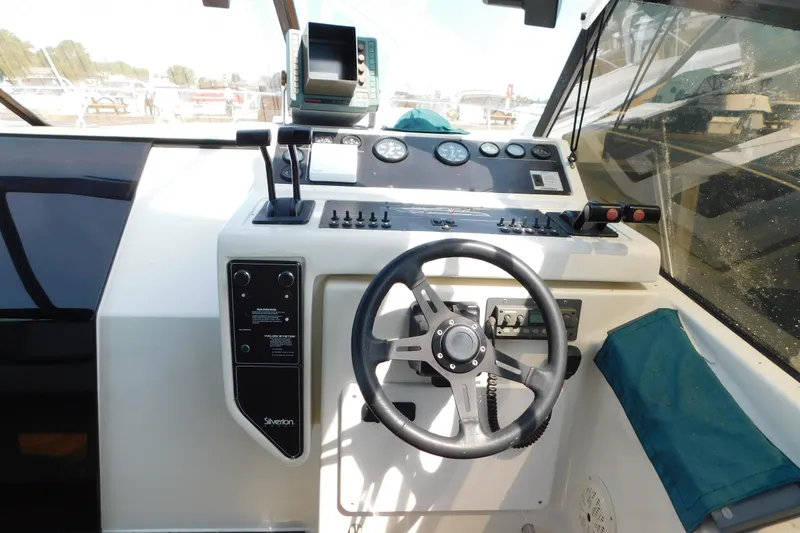 Slide: The Image of 1993 Silverton 34 Express boat helm with steering wheel and control panel. - 19