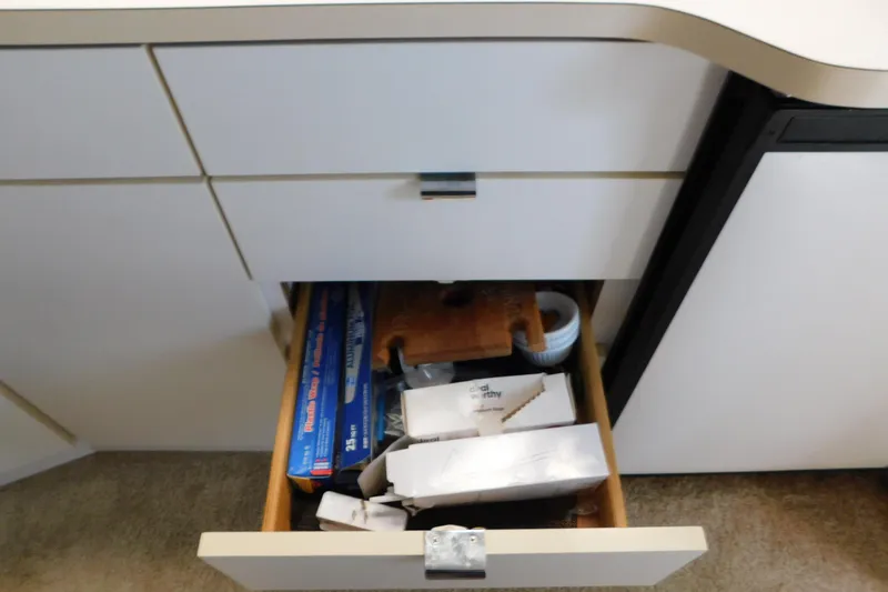Slide: The Image of Open drawer in 1993 Silverton 34 Express boat, containing kitchen items and foil. - 48
