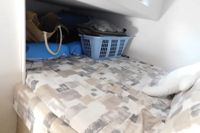 Slide: The Image of Interior cabin storage on 1993 Silverton 34 Express boat with bedding and laundry basket. - 63