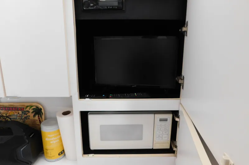 Slide: The Image of Cabinet with TV and microwave in 1993 Silverton 34 Express boat interior. - 33