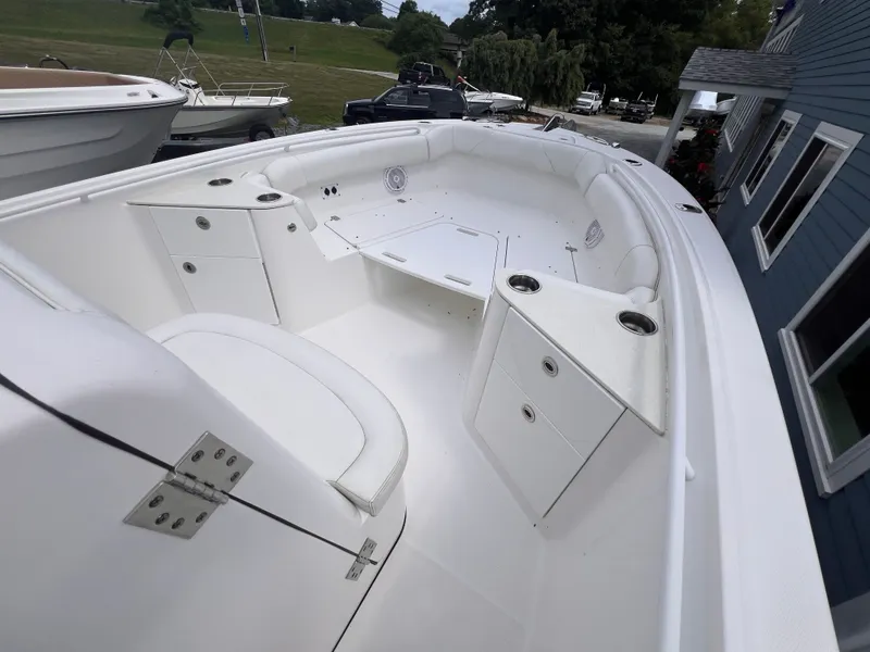 Slide: The Image of The image shows the spacious bow area of an Edgewater 262CC boat with white upholstery and storage. - 28