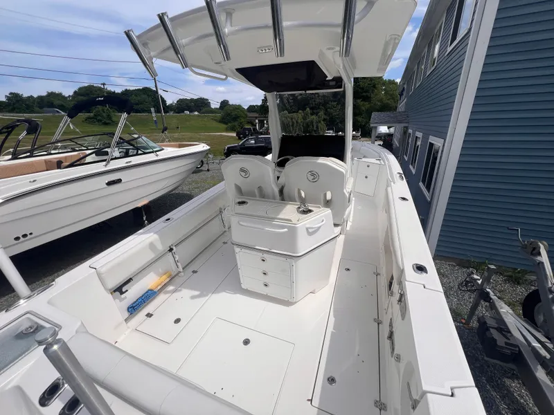 Slide: The Image of A 2021 Edgewater 262CC with a spacious deck, two seats, and a central helm station. - 11