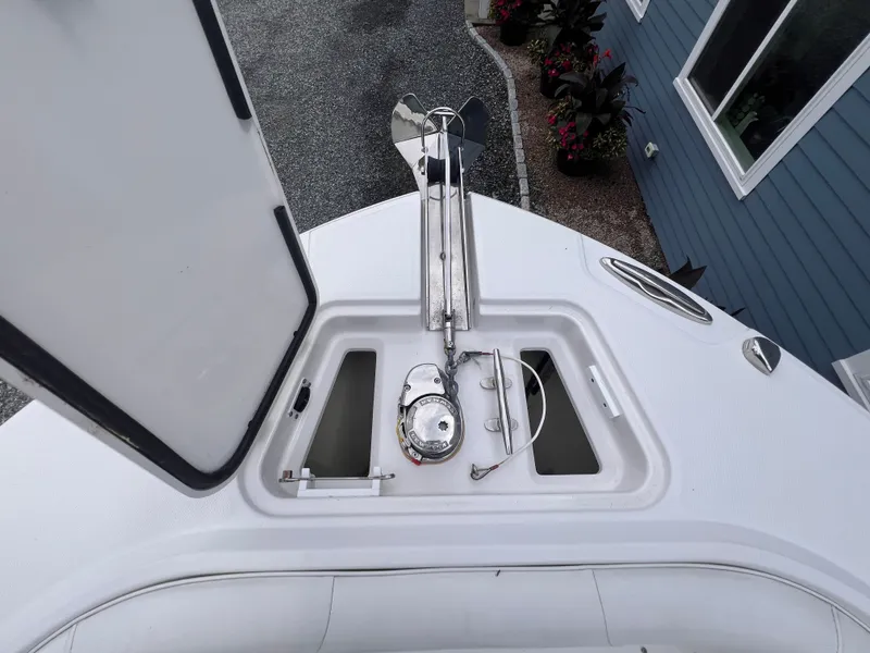 Slide: The Image of The image shows the bow of a 2021 Edgewater 262CC boat with an open anchor locker. - 29