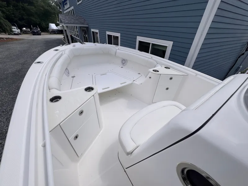 Slide: The Image of The image shows the deck of a 2021 Edgewater 262CC boat with white upholstery. - 27