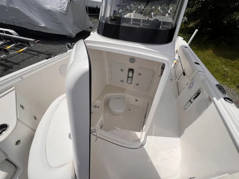 Slide: The Image of The image shows the cockpit of a 2021 Edgewater 262CC with a small toilet. - 36