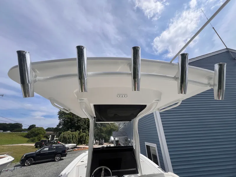 Slide: The Image of The image shows the T-top of an Edgewater 262CC boat with multiple fishing rod holders. - 25
