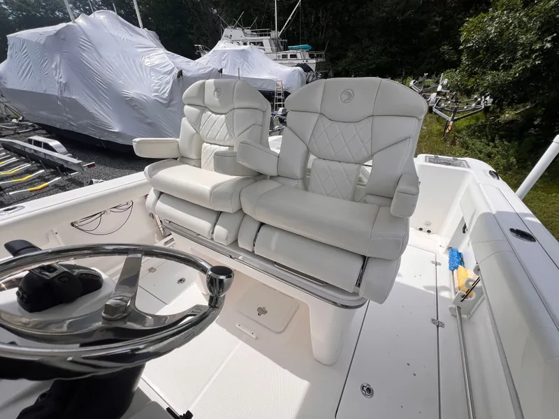 Slide: The Image of The image shows the cockpit of a 2021 Edgewater 262CC boat with two white cushioned seats. - 19