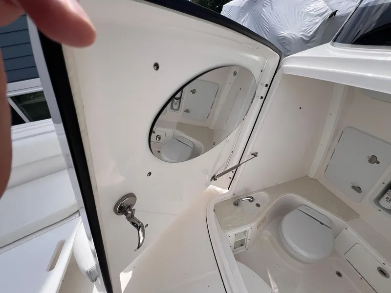 Slide: The Image of The image shows a boat bathroom interior with a round mirror and a sink. - 38
