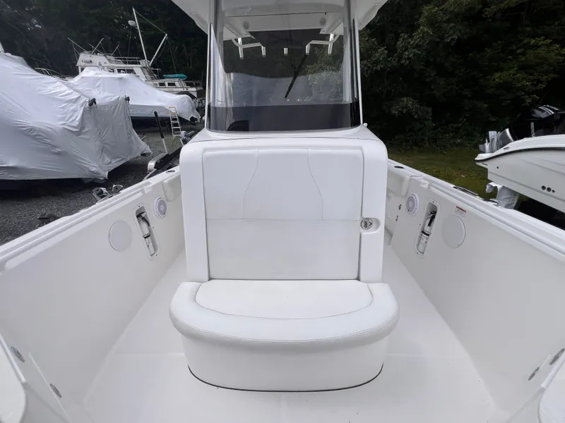 Slide: The Image of The image shows the cockpit of a 2021 Edgewater 262CC boat with white upholstery. - 32