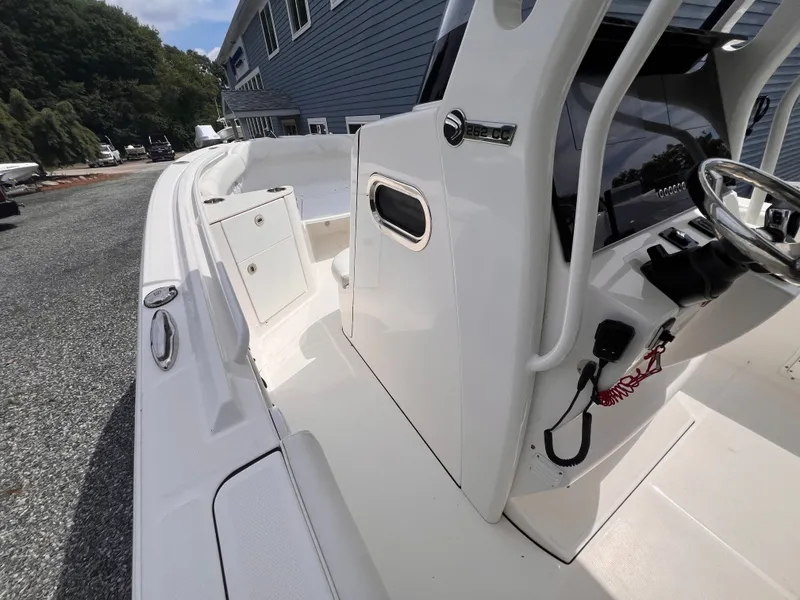 Slide: The Image of The image shows the cockpit of a 2021 Edgewater 262CC boat with a helm console and storage. - 26