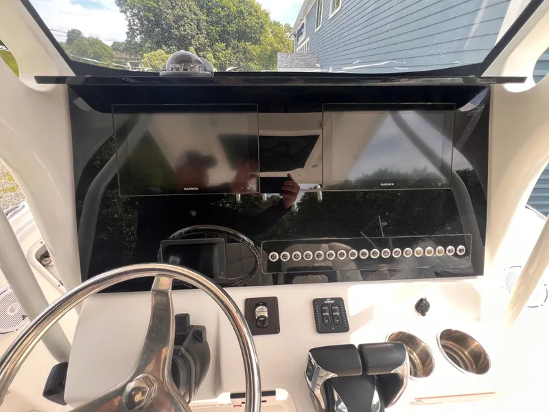 Slide: The Image of The image shows the cockpit of a 2021 Edgewater 262CC boat with modern Garmin screens. - 22