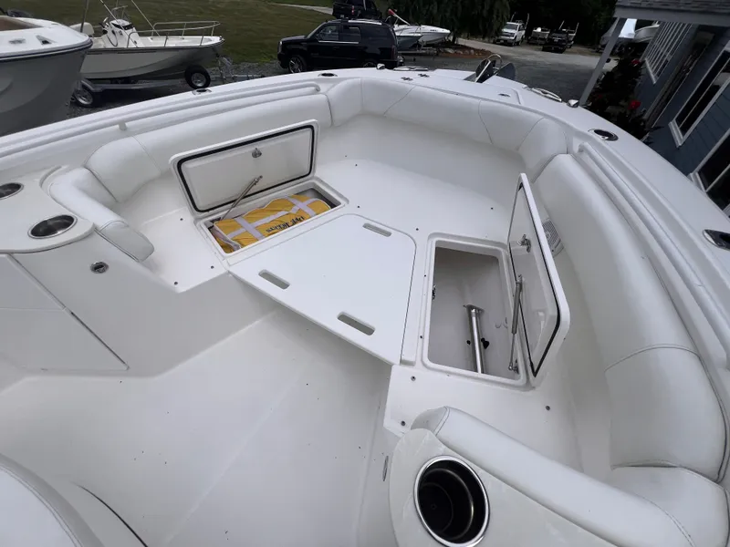 Slide: The Image of The image shows the cockpit of an Edgewater 262CC boat with white upholstery and storage compartments. - 31
