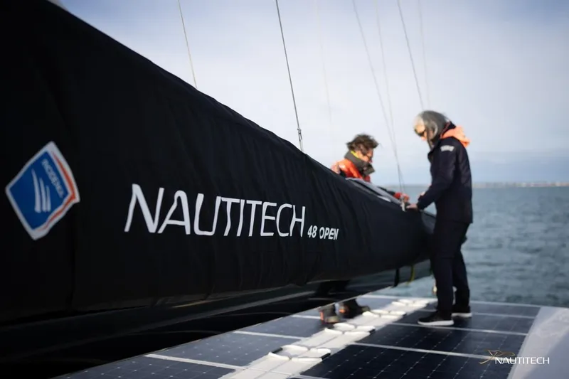 Slide: The Image of Two people stand on a catamaran with "Nautitech 48 Open" written on the sail. - 21