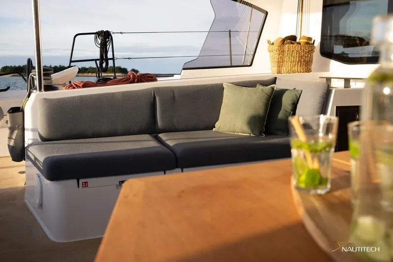 Slide: The Image of The image shows the cockpit of a Nautitech 48 Open with gray cushions and a wooden table. - 13