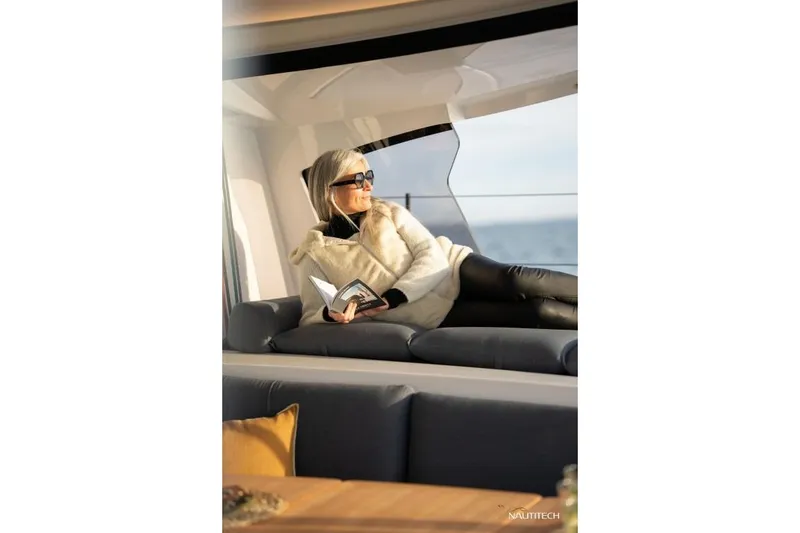 Slide: The Image of A woman relaxes on a sofa in a modern yacht, reading a book. - 20