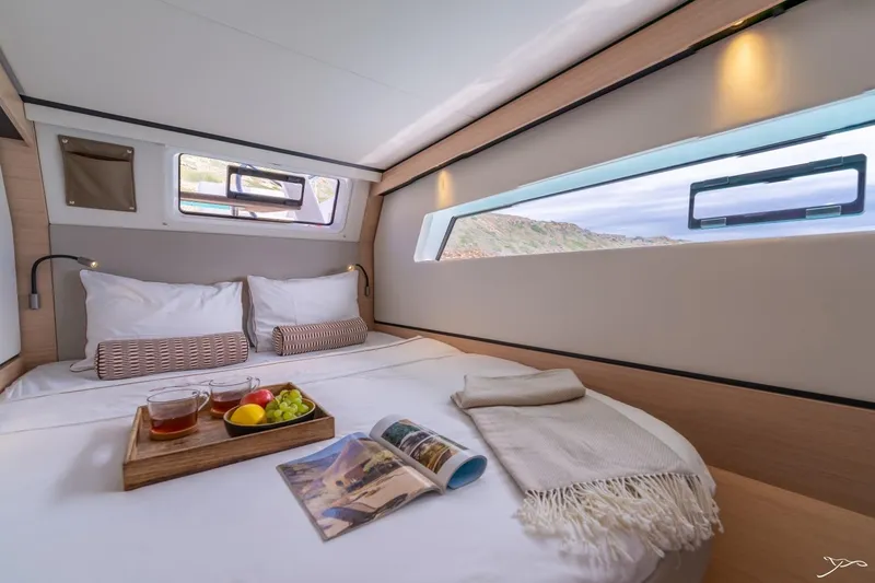 Slide: The Image of Cozy cabin with a double bed, tray with drinks and fruit, and a window with sea view. - 35