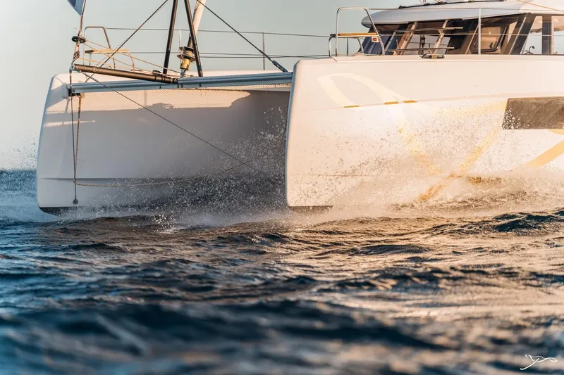 Slide: The Image of A modern catamaran sails dynamically through the water, with splashing waves at the side. - 26